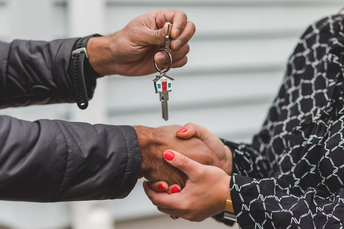 Person handing over keys to new home owner